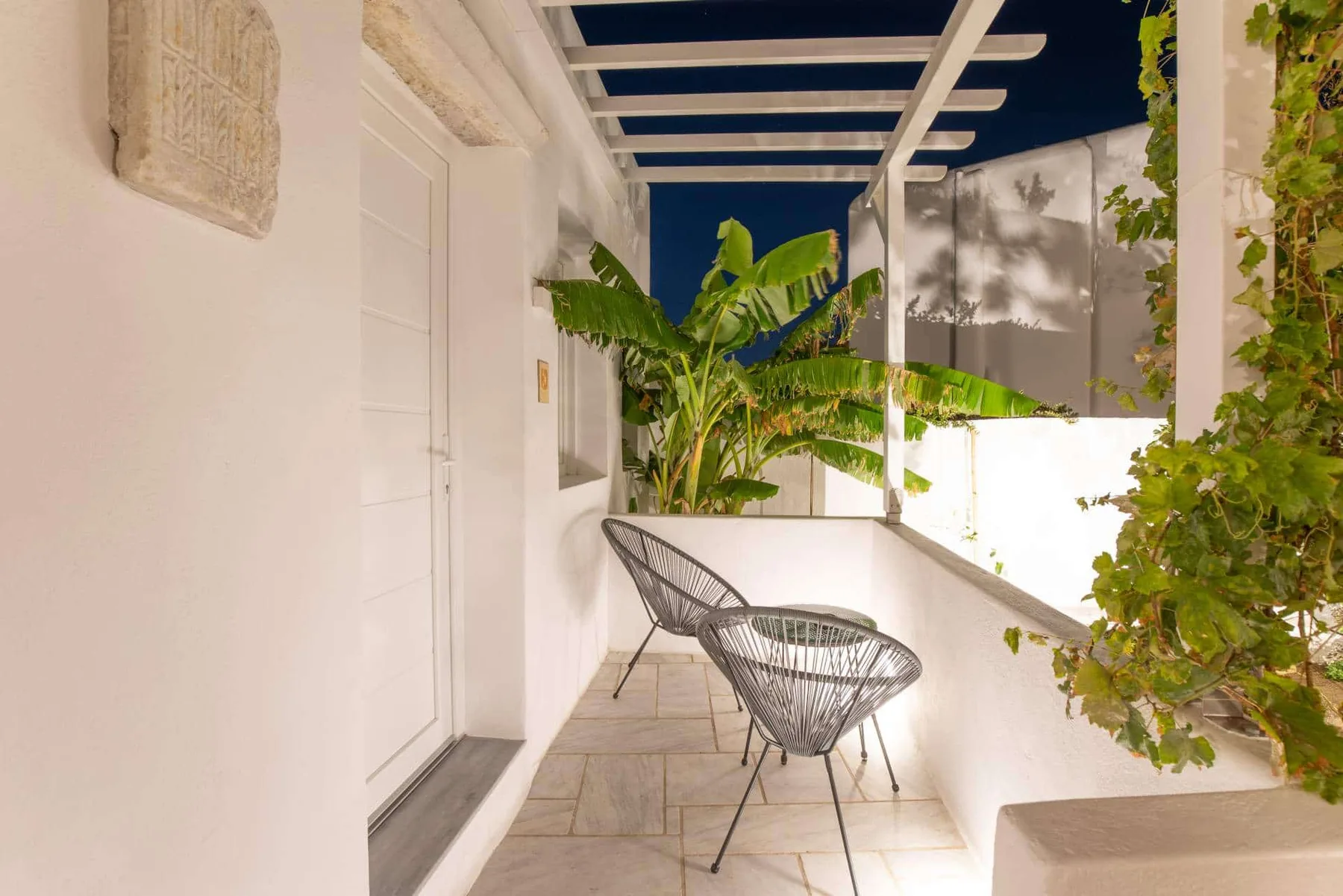 Terrace with rope chairs under the pergola at night